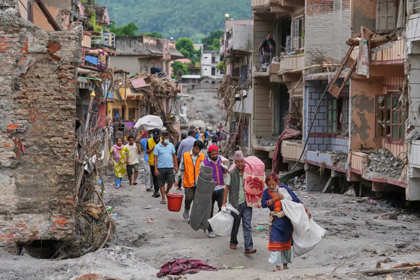 Abaturage bakuraga mu ngo zabo ibyangiritse n’ibyo babashije kurokora nyuma y’imyuzure i Devighat, Nuwakot muri Nepal.